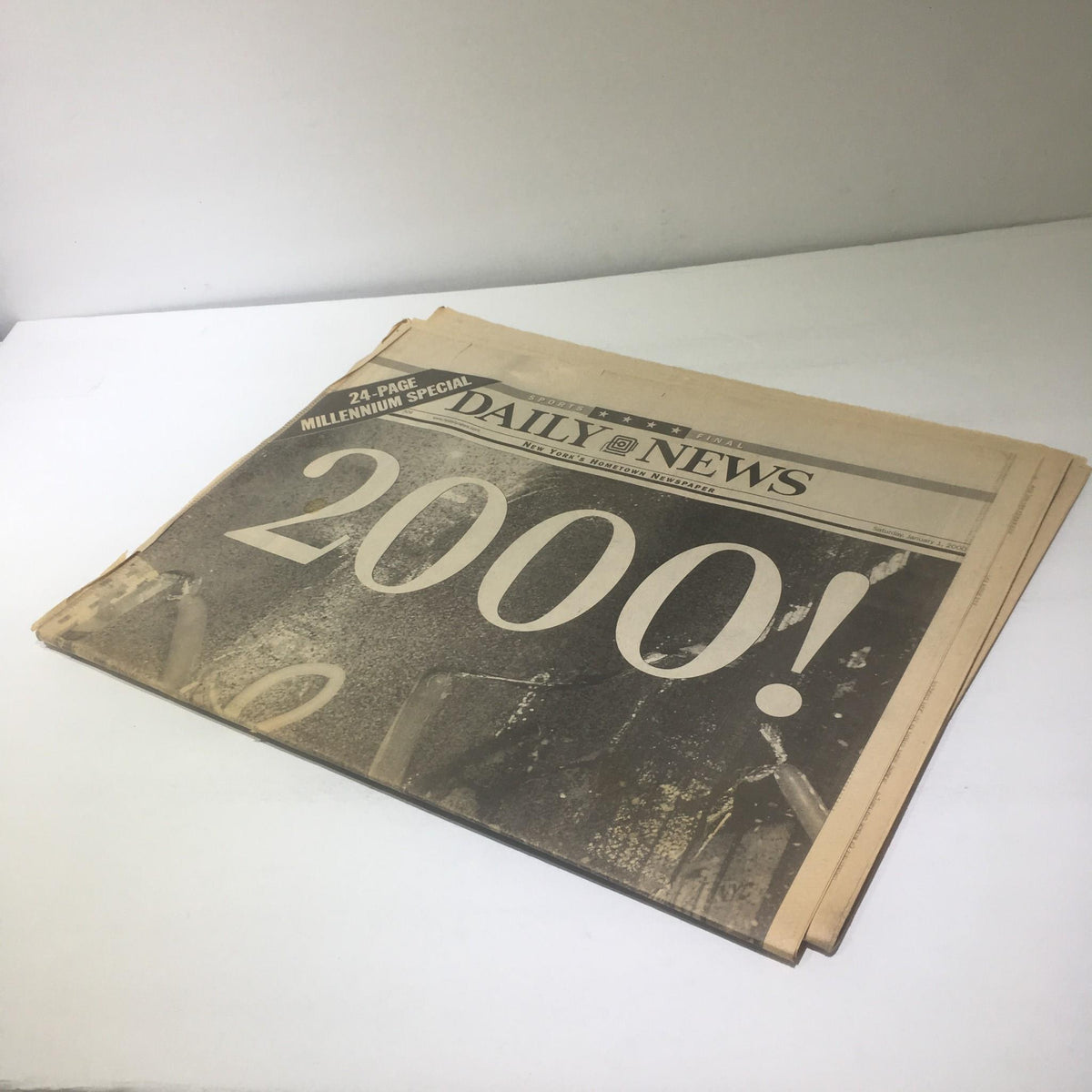 Picture of the NY Daily News cover from 1/1/2000, featuring bold text '2000!' and celebrating the largest peacetime crowd in Times Square.