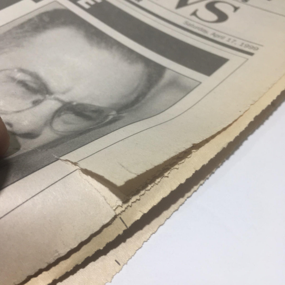 Close-up showing a tear in the edge of the NY Daily News newspaper from April 17, 1999, highlighting its vintage condition.