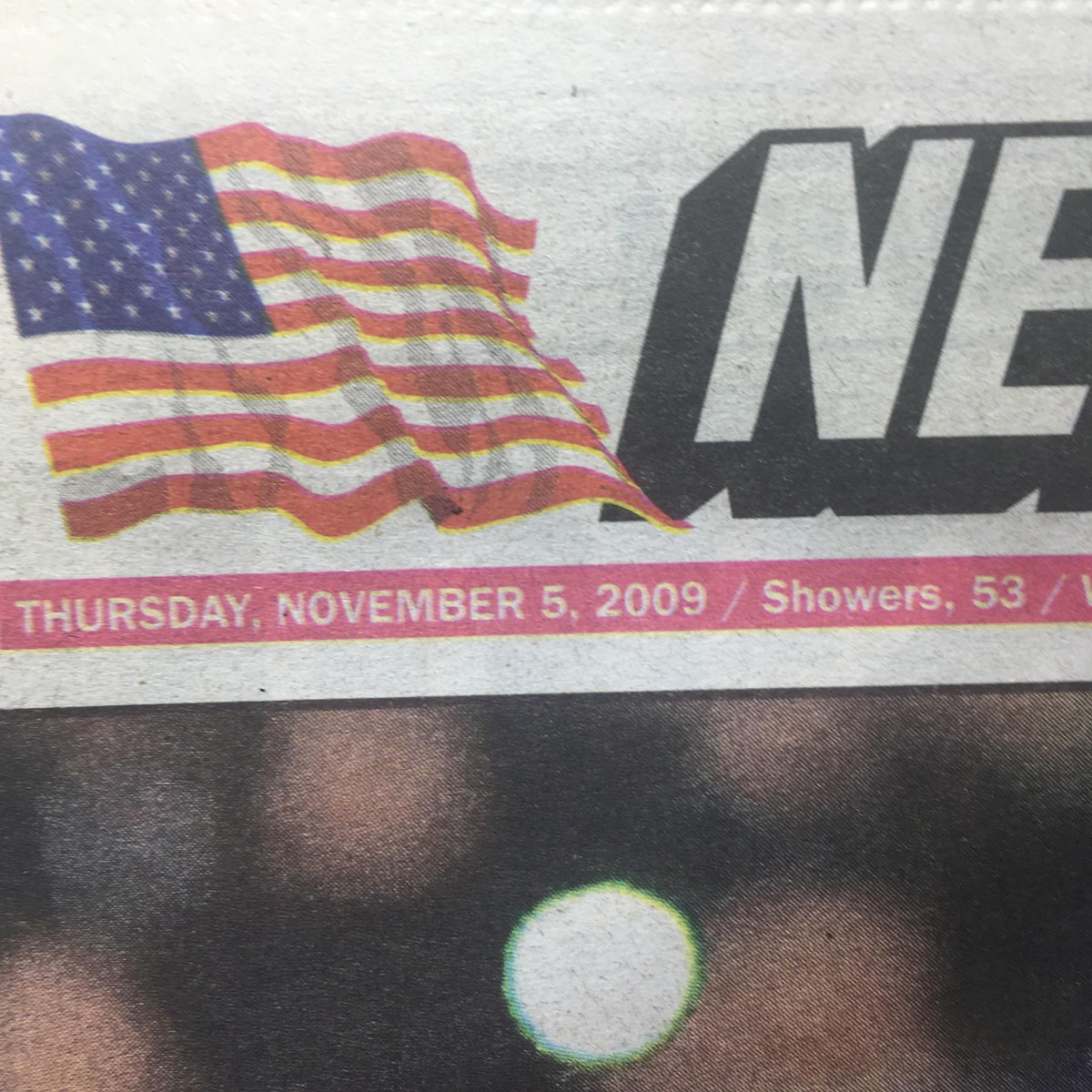 Close-up of the New York Post headline dated November 5, 2009, displaying the date and weather, alongside an American flag graphic.