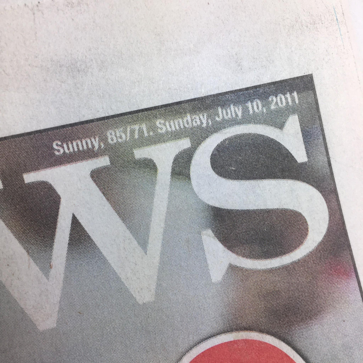 Close-up of the New York Daily News dated July 10, 2011, indicating the weather report with sunny conditions, part of the publication's design and layout.