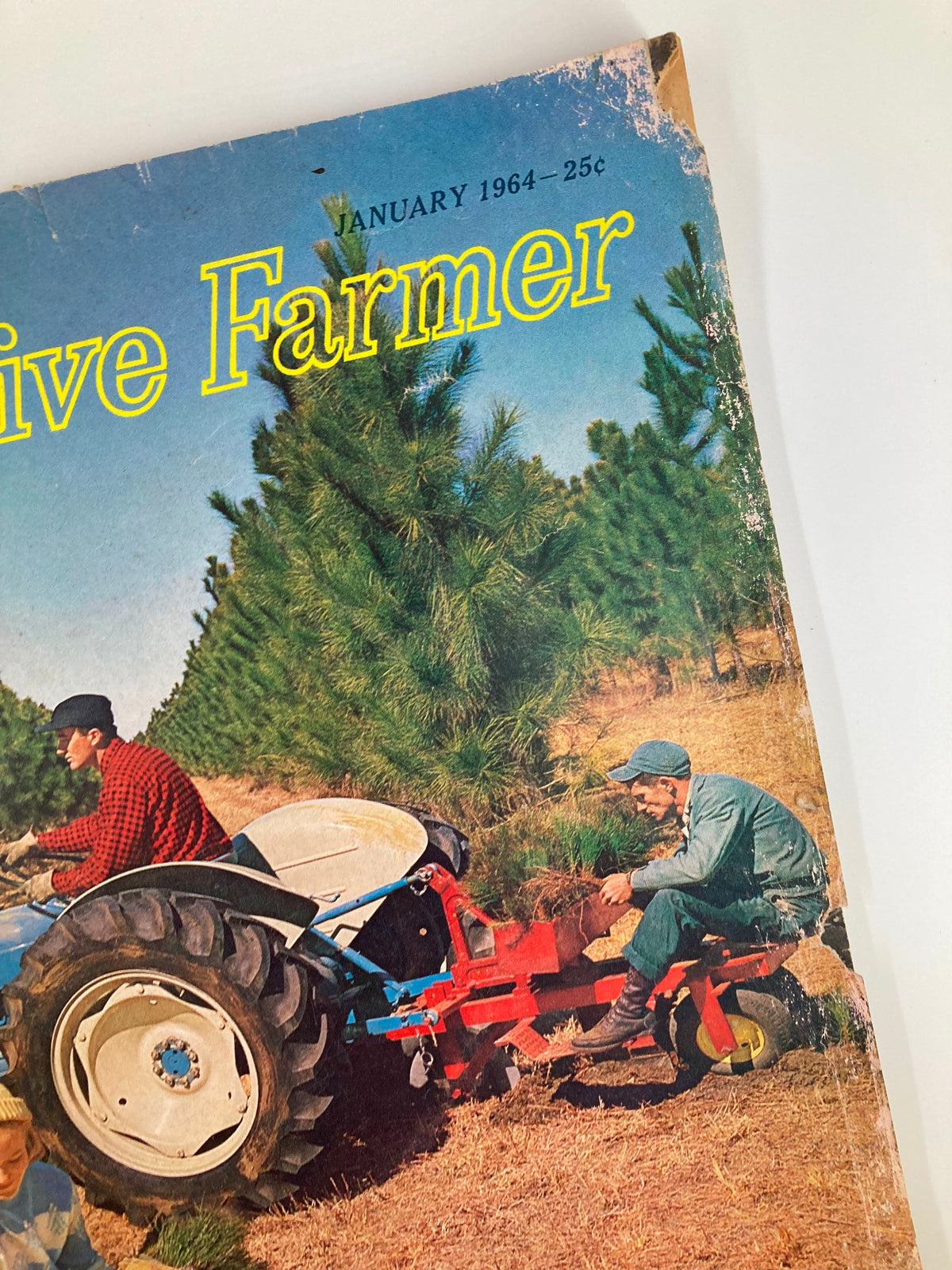 Close-up view of The Progressive Farmer magazine cover from January 1964, highlighting the vintage design, including the title and details of farming illustrated with a tractor and workers.
