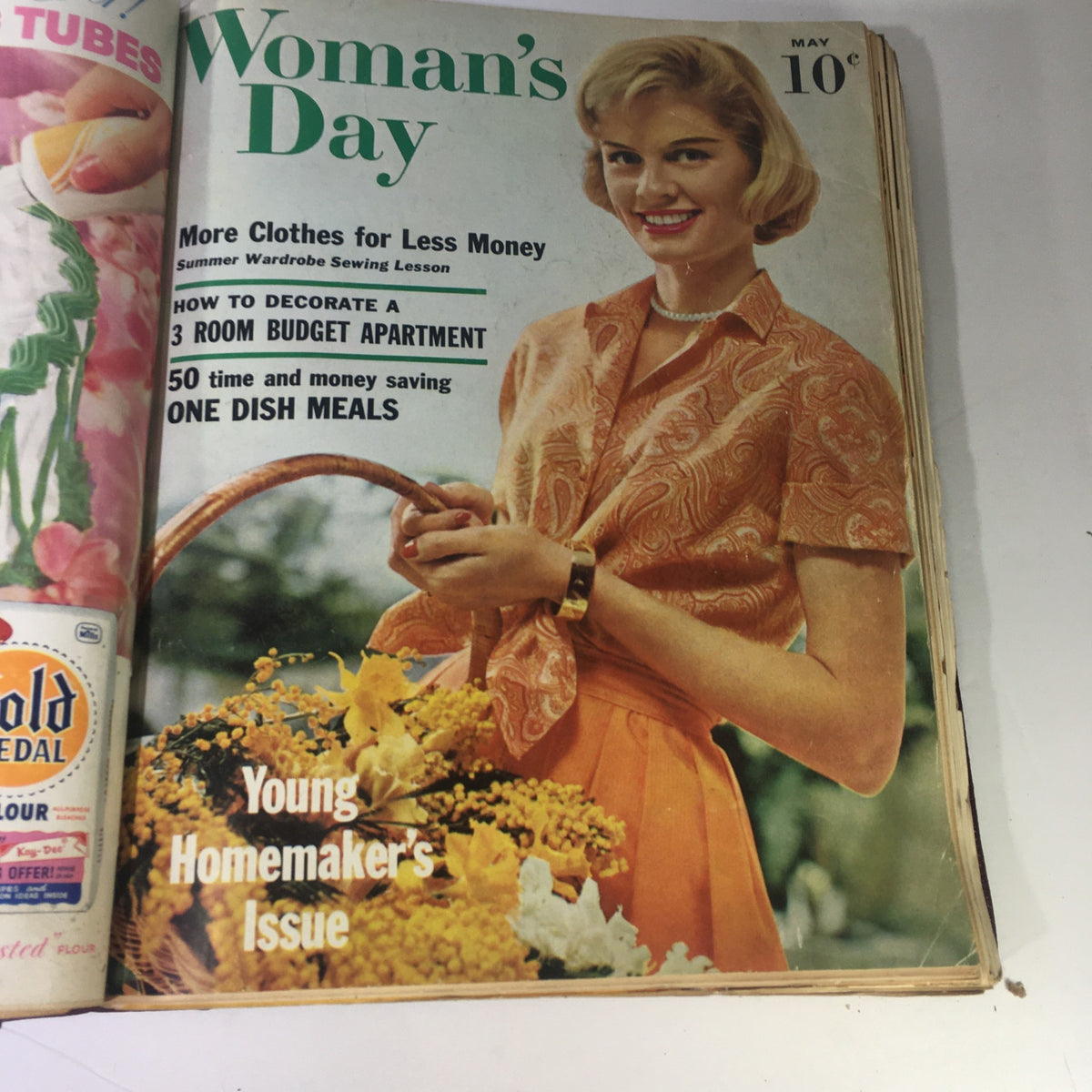 Cover of the May 1959 Woman's Day Magazine showcasing a stylish woman in a floral outfit, with tips on budget decorating and one dish meals.
