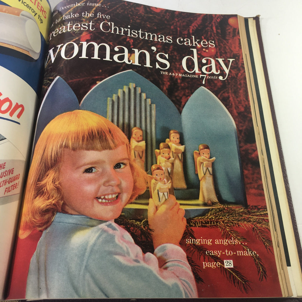 December issue cover of 1954 Woman's Day Magazine showcasing a young girl with a cheerful smile next to decorative Christmas cakes, embodying the festive spirit.