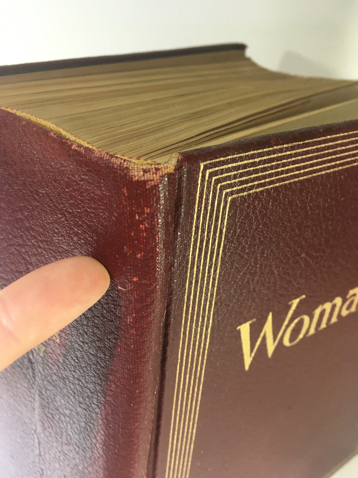 Close-up view of the worn edge of the 1952 Woman's Day Magazine Complete Year Round In One Book Compilation, showcasing its vintage charm and condition.