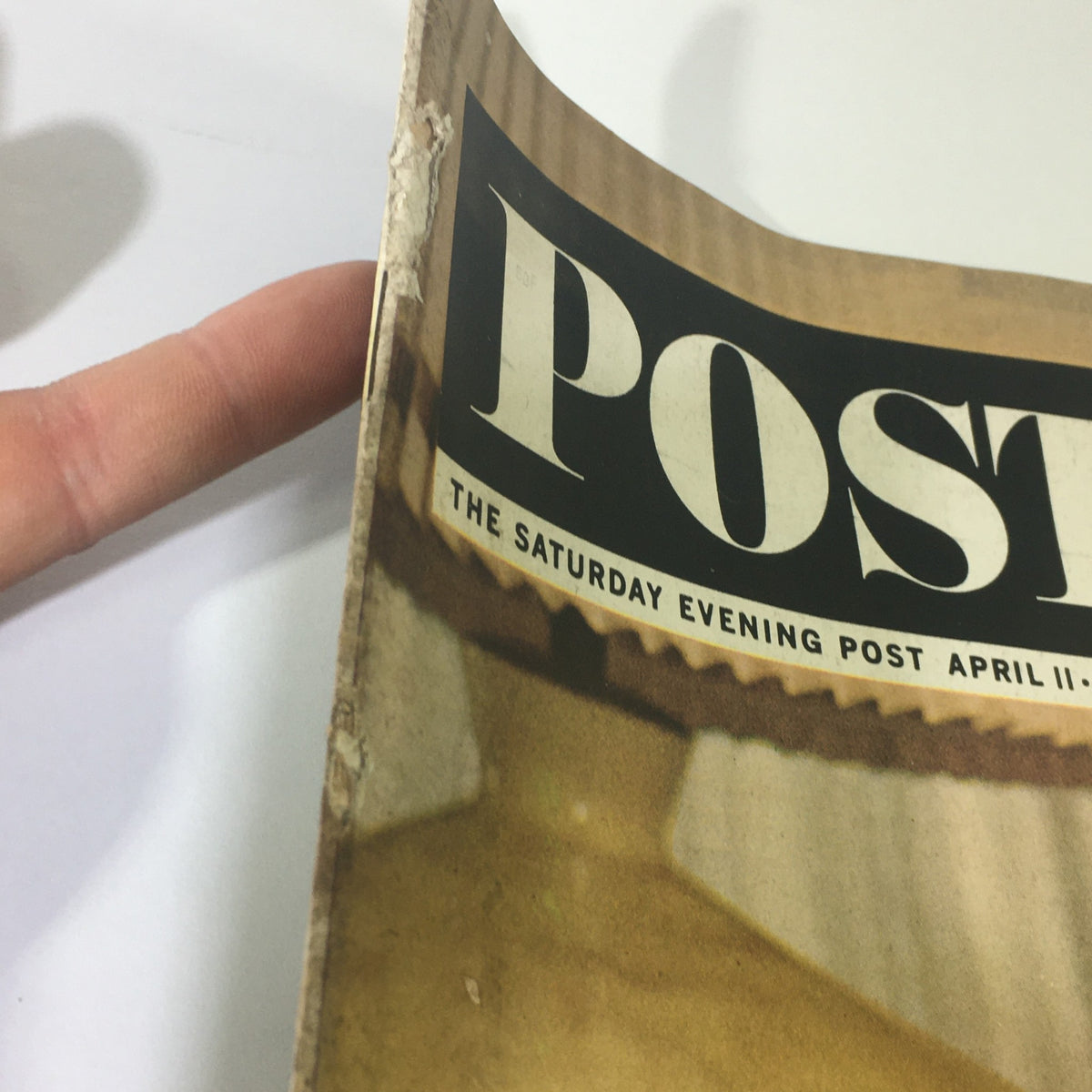 Close-up of the spine of VTG The Saturday Evening Post April 11 1964, highlighting wear and age, emphasizing its vintage condition.