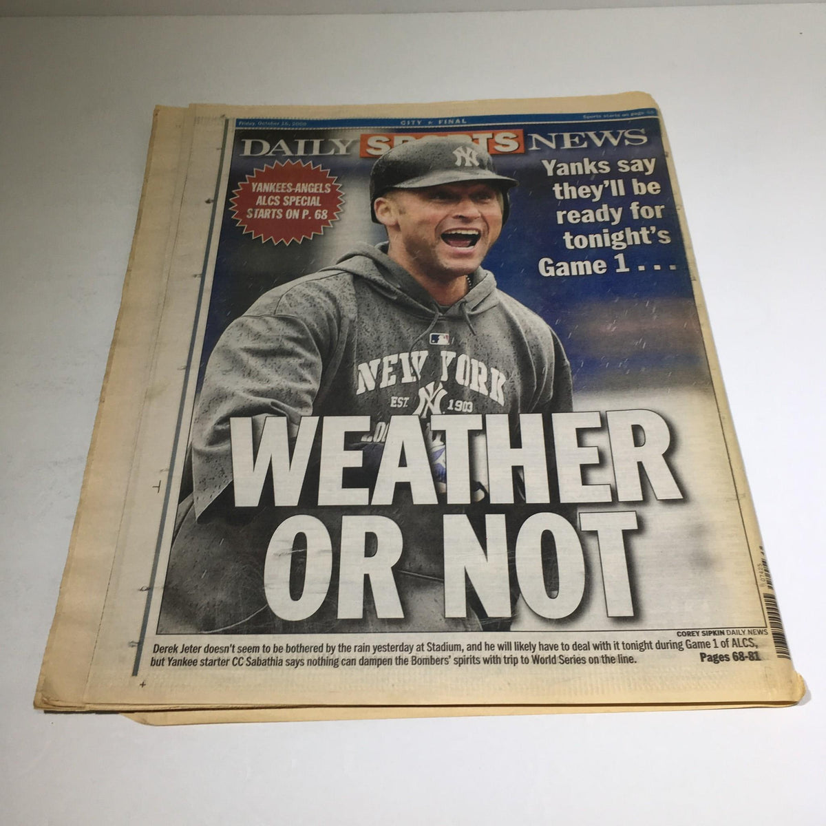 Back view of the New York Daily News newspaper showcasing another sports headline 'WEATHER OR NOT' related to the Yankees' playoff game, relevant to the 'HEAT OF THE NIGHT' edition.