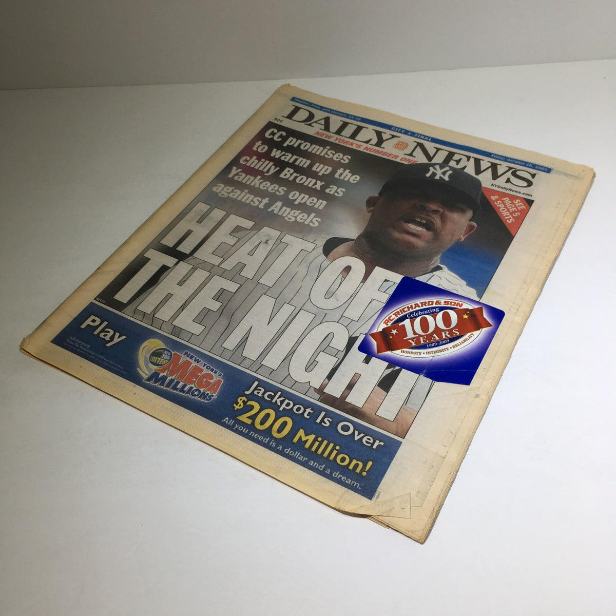 Another angle of the New York Daily News from October 16, 2009, highlighting the headline 'HEAT OF THE NIGHT' featuring CC Sabathia, with a promotional sticker indicating the Mega Millions lottery jackpot.