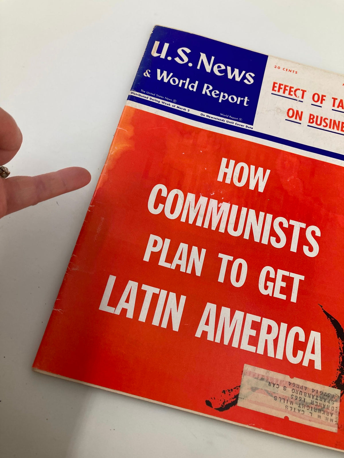 Close-up view of the US News & World Report Magazine cover from March 9, 1964, emphasizing the headline 'How Communists Plan to Get Latin America' with a hand gesture pointing at the text.