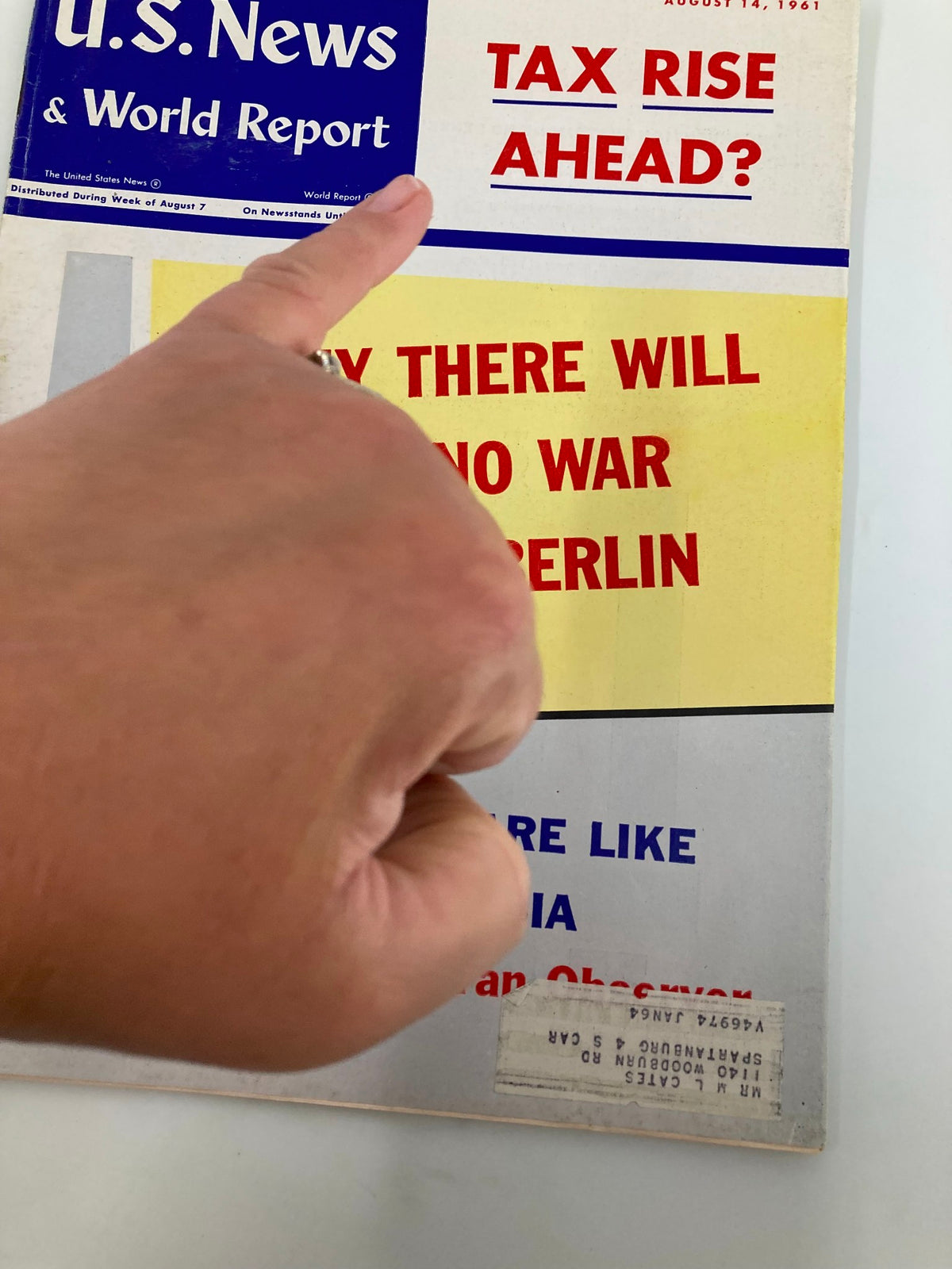 Detail view of the US News & World Report Magazine August 14, 1961 cover with a hand pointing at the headline 'Tax Rise Ahead?' and showing magazine wear.