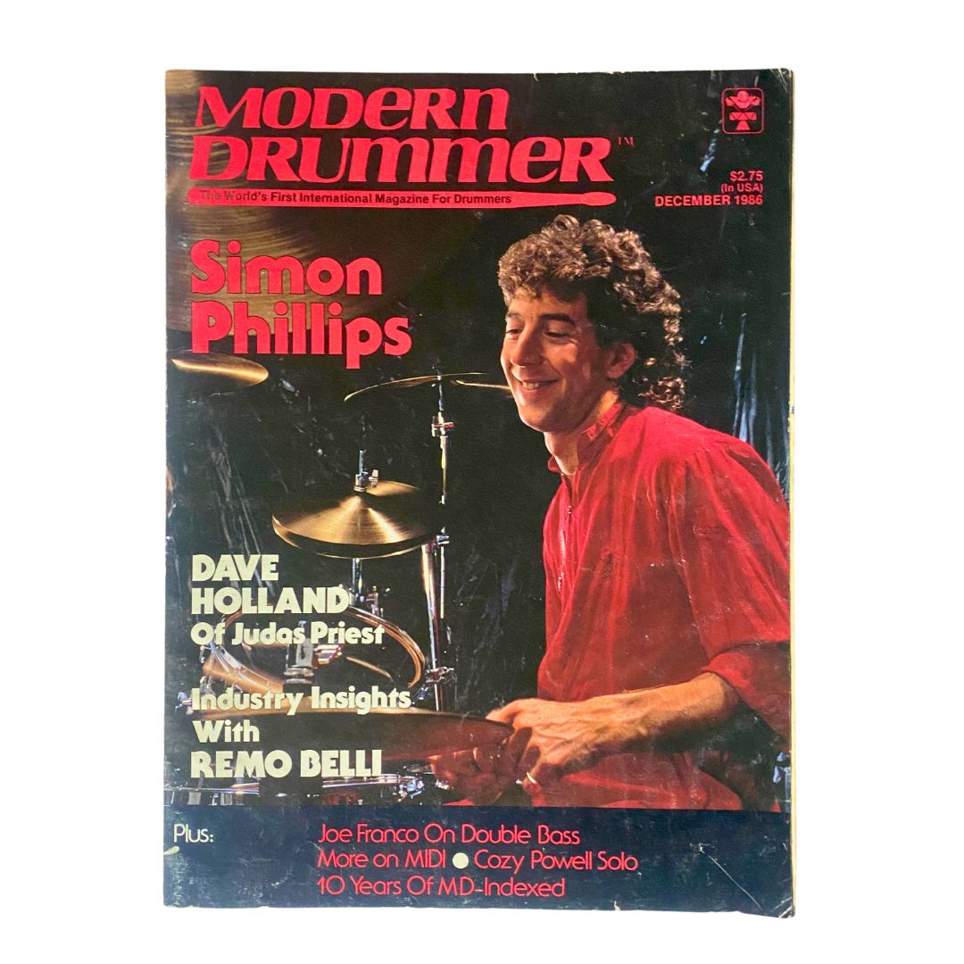 Cover of VTG Modern Drummer Magazine December 1986 featuring Simon Phillips, showcasing his drumming talent. Includes highlights on Dave Holland and Remo Belli.