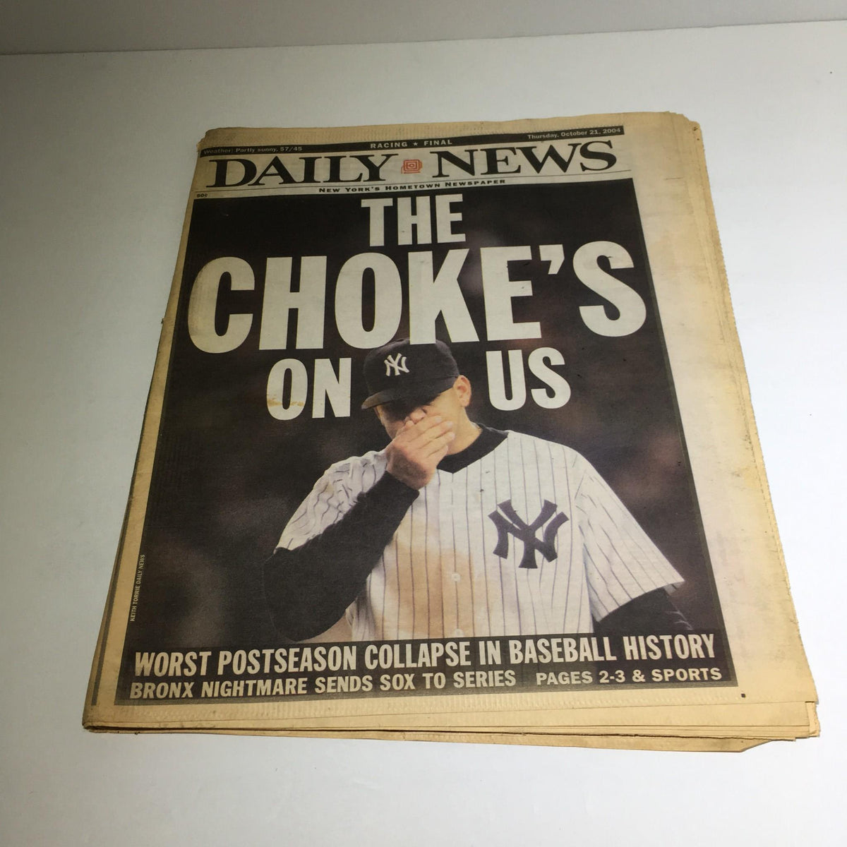 New York Daily News newspaper from October 21, 2004, titled 'The Choke's on US', featuring a Yankees player with a distressed expression, highlighting the headline about the worst postseason collapse in baseball history.