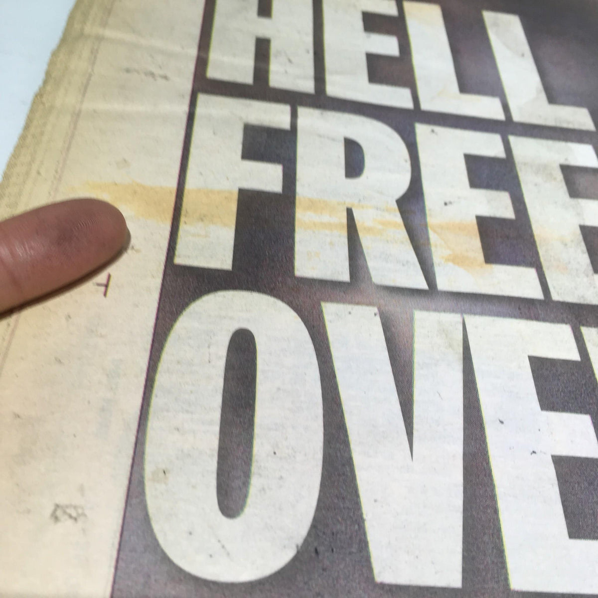 Detailed view of the New York Daily News cover featuring the headline 'Hell Freezes Over', showcasing light staining and wear, typical of vintage publications.