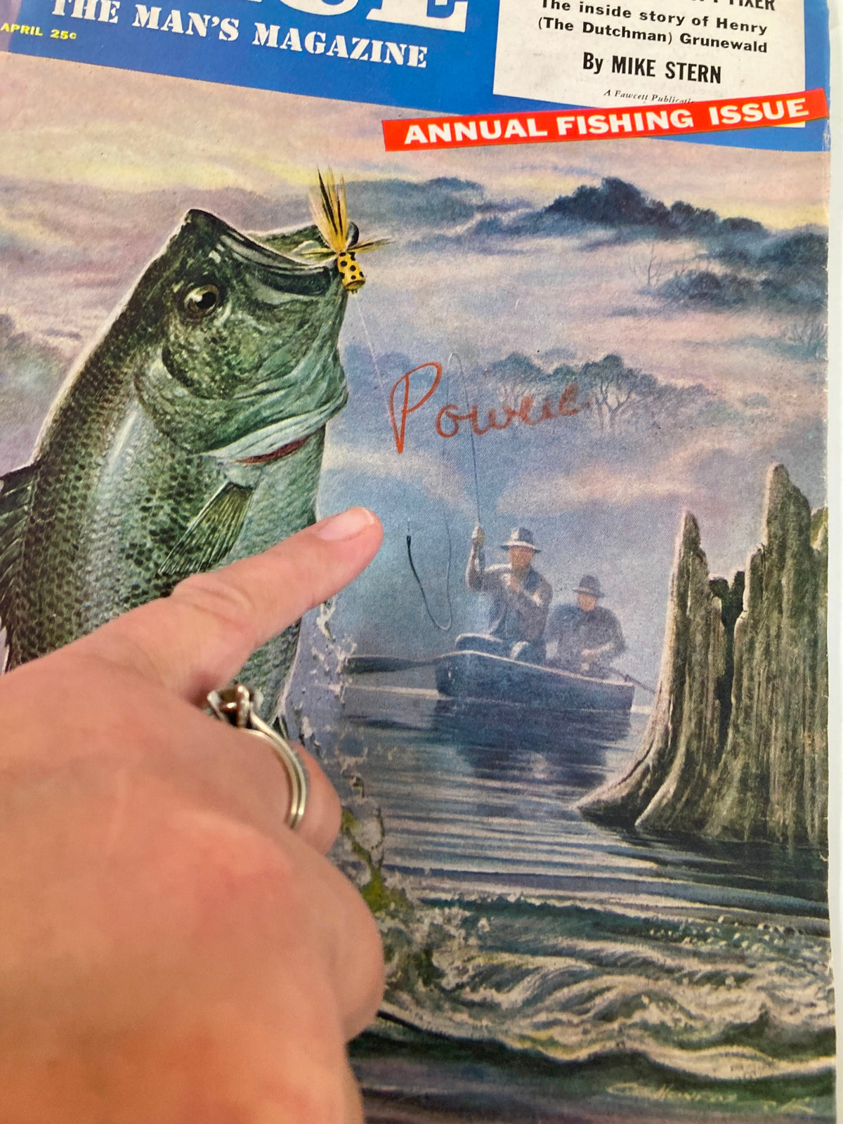 Close-up of the cover of TRUE The Man's Magazine April 1954 with a finger pointing at the fish illustration, highlighting the annual fishing issue.