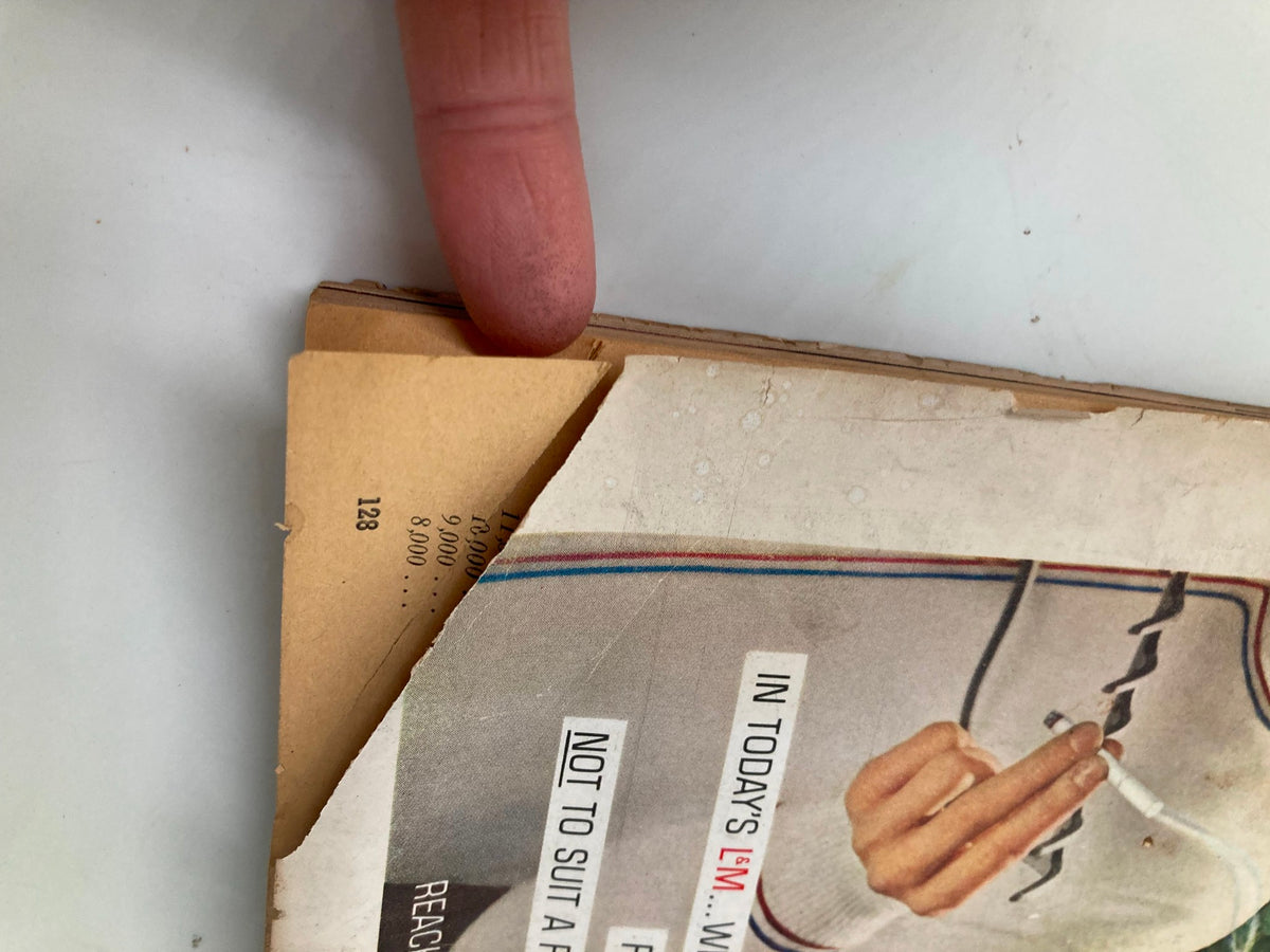 Close-up image of a page from TRUE The Man's Magazine July 1960, showcasing a finger pointing to the corner of a page with visible magazine details and minor wear, reflecting its vintage character.