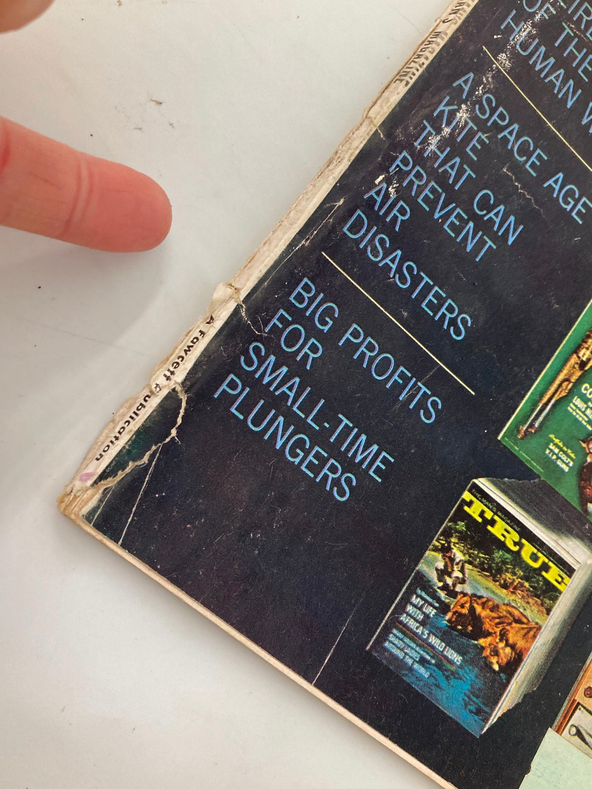 Close-up of the spine of TRUE The Man's Magazine January 1963 showing wear and details like article titles including 'Big Profits for Small-Time Plungers'.