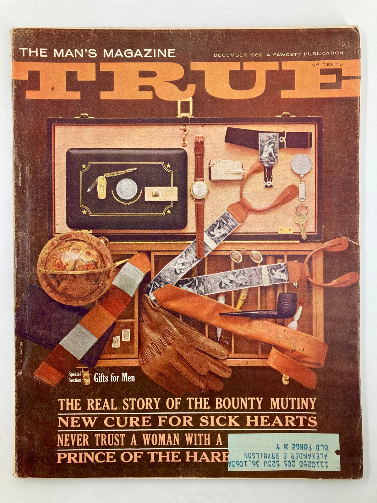 Cover of TRUE The Man's Magazine December 1962, featuring the headline 'The Real Story of The Bounty Mutiny', showcasing vintage artwork with various objects, including a globe, gloves, and a charm bracelet.