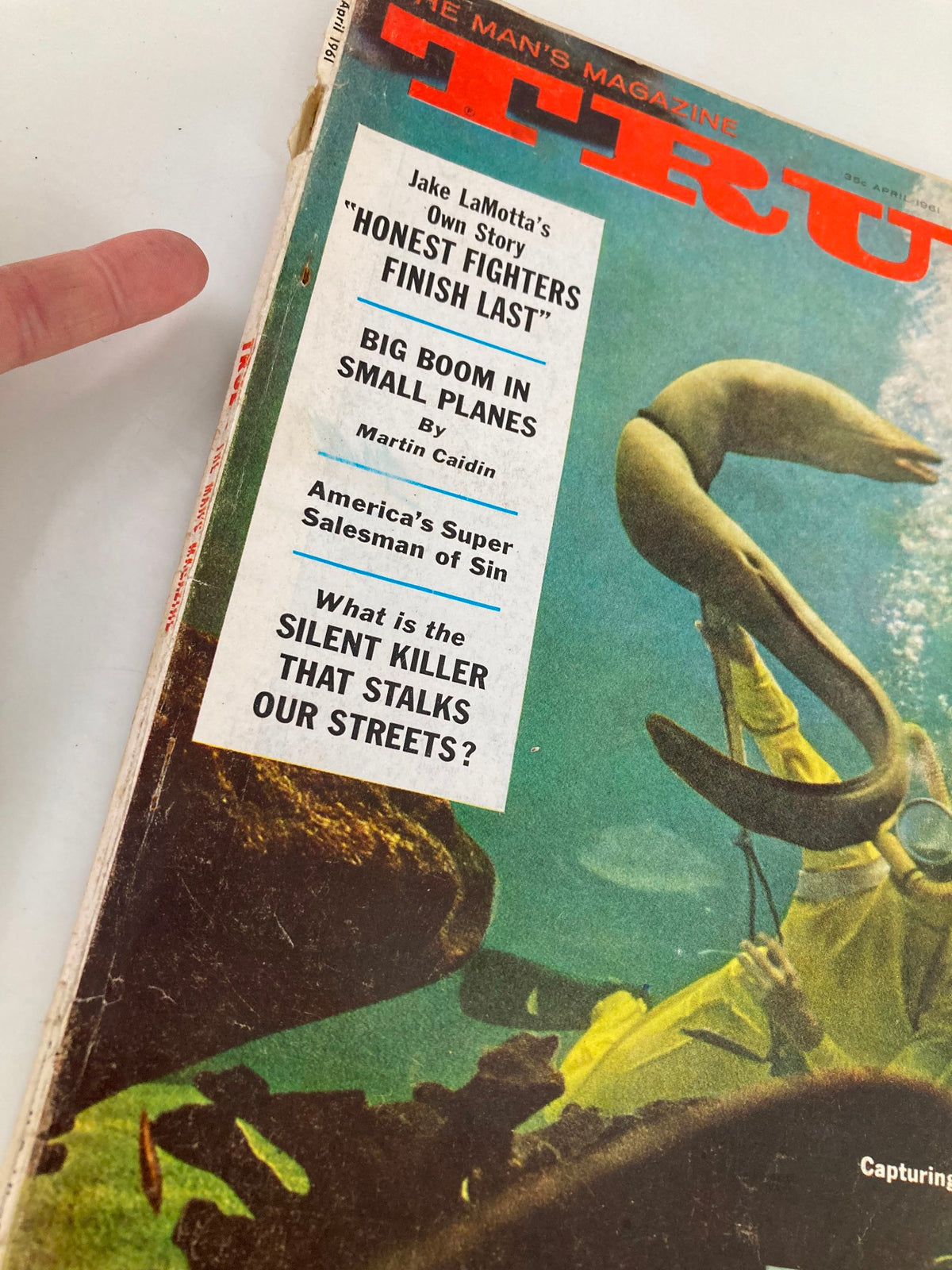 Close-up of the cover of TRUE The Man's Magazine April 1961 highlighting articles such as 'Honest Fighters Finish Last' by Jake LaMotta and a focus on gun rights.