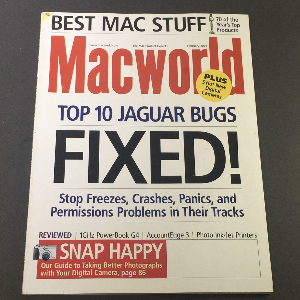 Cover of Mac World Catalog, February 2003, featuring 'Best Mac Stuff' and 'Digital Camera Guide', showcasing top 10 Jaguar bugs fixed, with themes of digital cameras and technology.