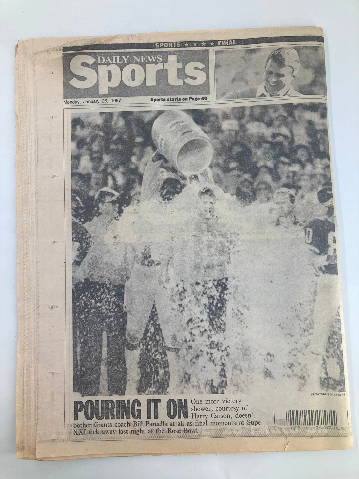 VTG Daily News Newspaper January 26, 1987, featuring Coach Bill Parcells celebrating after Super Bowl XXI, showcasing the victorious moment with players as they douse him with a victory shower.