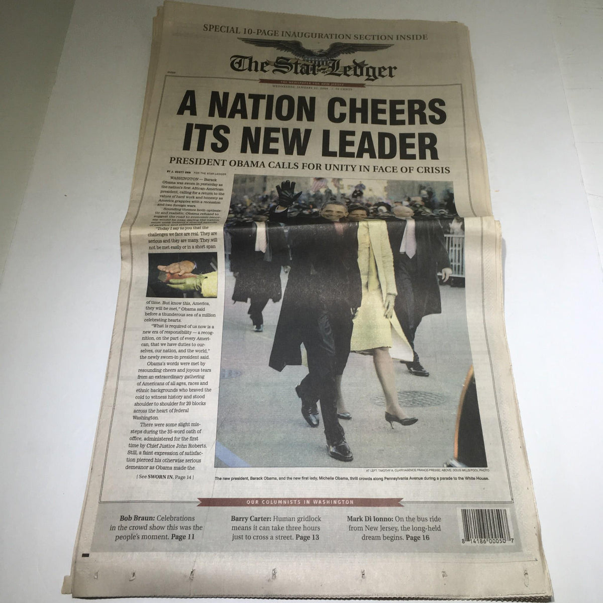 The Star Ledger newspaper dated January 21, 2009, featuring the headline 'A Nation Cheers Its New Leader' with President Obama depicted at his inauguration, calling for unity in the face of crisis.