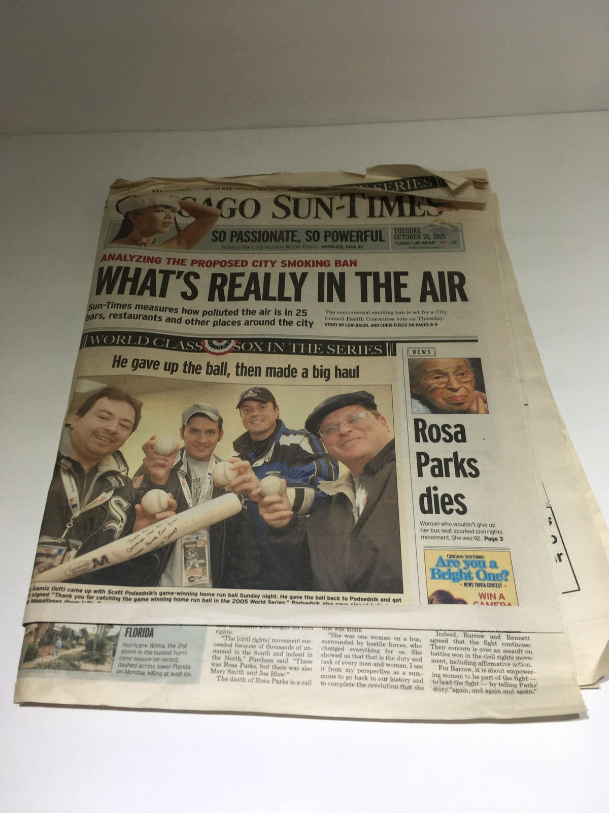 Chicago Sun-Times: October 25, 2005 edition featuring the headline 'What's Really in the Air' and a group of individuals celebrating a major event, showcasing the essence of news from that time.