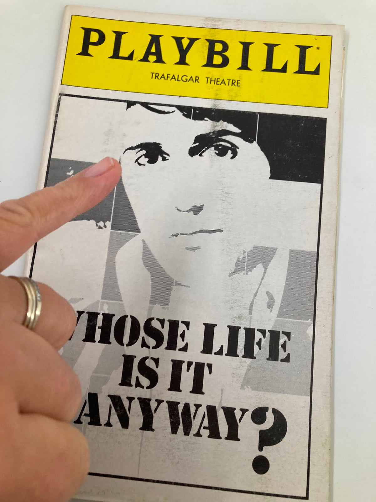 Close-up of the 1979 Playbill from Trafalgar Theatre for 'Whose Life Is It Anyway?' showcasing a finger pointing to the iconic cover.