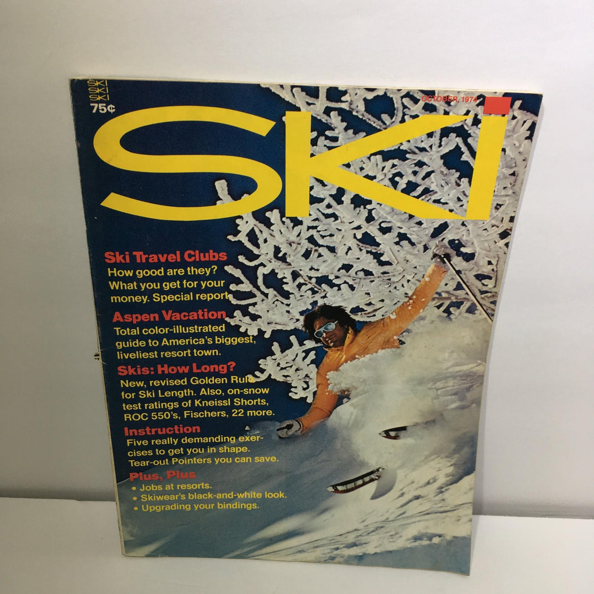 Cover of Ski Magazine from October 1974 featuring articles on ski travel clubs and an Aspen vacation, with a skier in action amidst snow-covered trees.