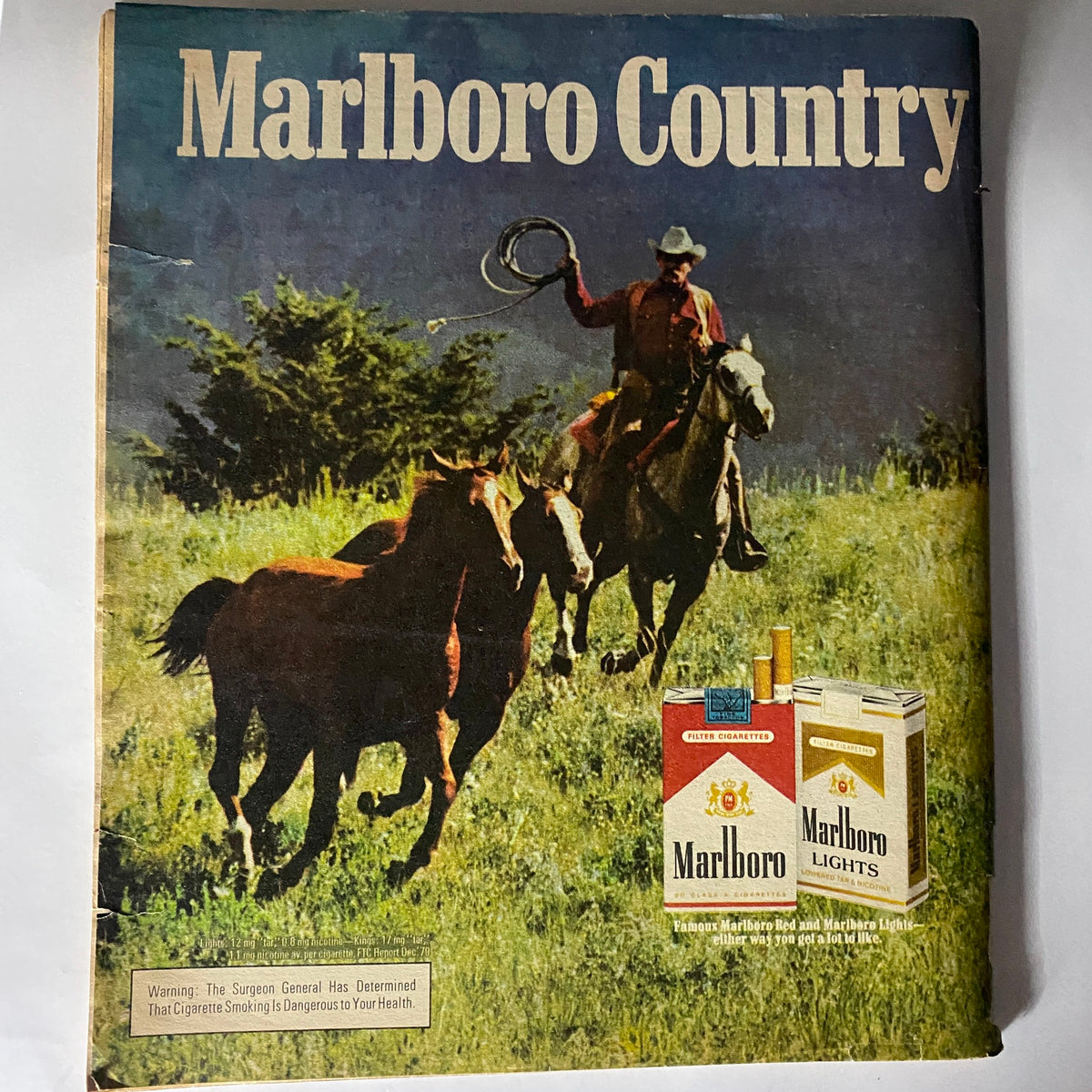 Another vintage magazine cover showcasing Marlboro Country, depicting a cowboy on horseback roping cattle, representing classic Americana alongside the Marlboro brand.