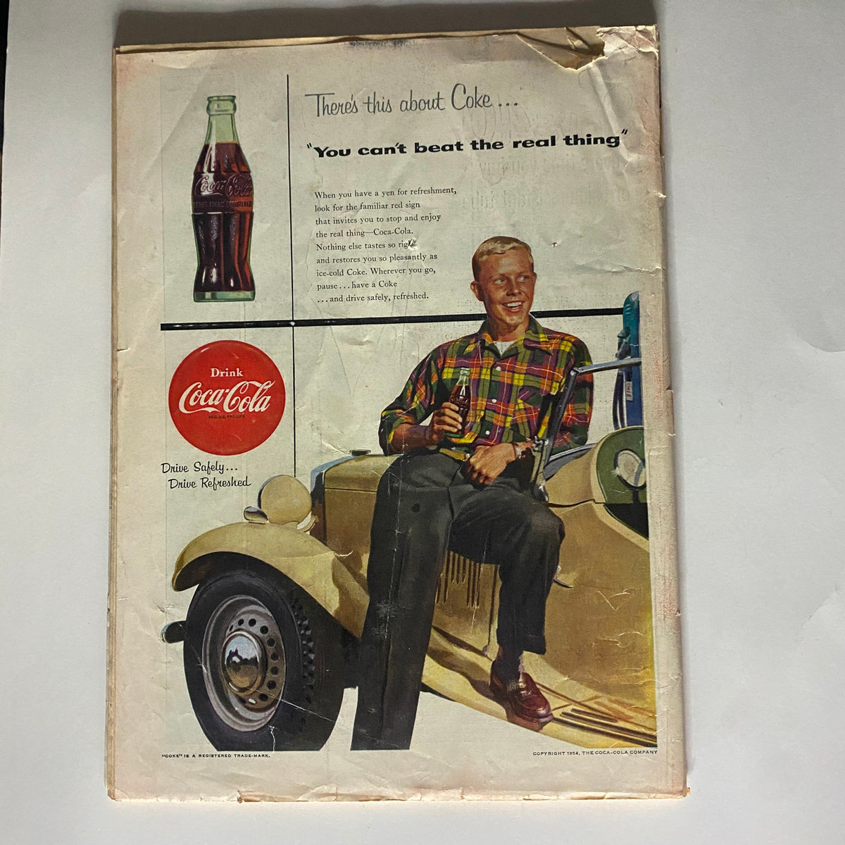Vintage advertisement featuring a smiling young man holding a Coca-Cola bottle while sitting in a classic car, from the VTG Time Magazine June 7, 1954 Vol 63 No. 23 Humphrey Bogart as Capt. Queeg.