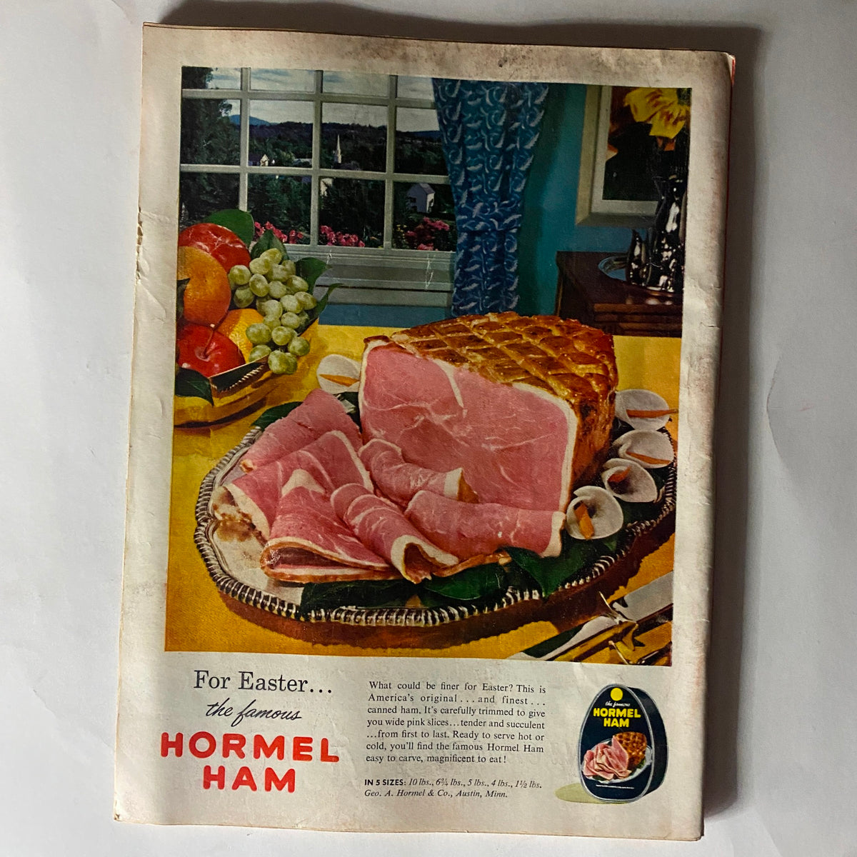 Vintage advertisement featuring Hormel Ham for Easter, featured in VTG Time Magazine April 8, 1957. Showcases a platter of sliced ham with a colorful table setting, including fruits and flowers, highlighting American culinary traditions.