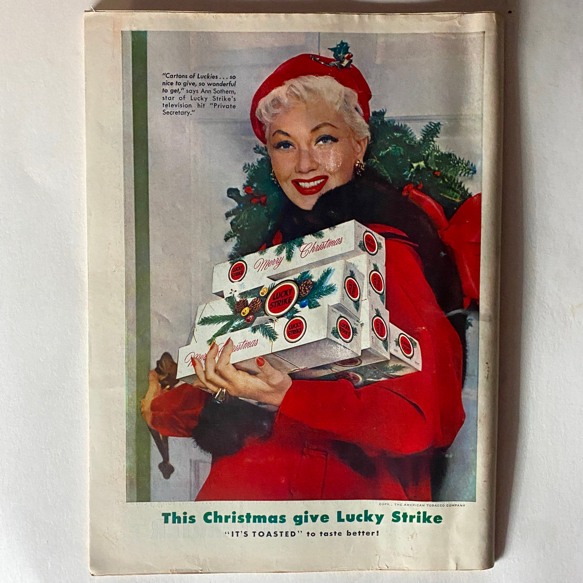 Cover of VTG Time Magazine December 13, 1954 showcasing a Christmas advertisement for Lucky Strike, featuring a smiling woman in a red coat holding cigarette boxes with festive decorations.