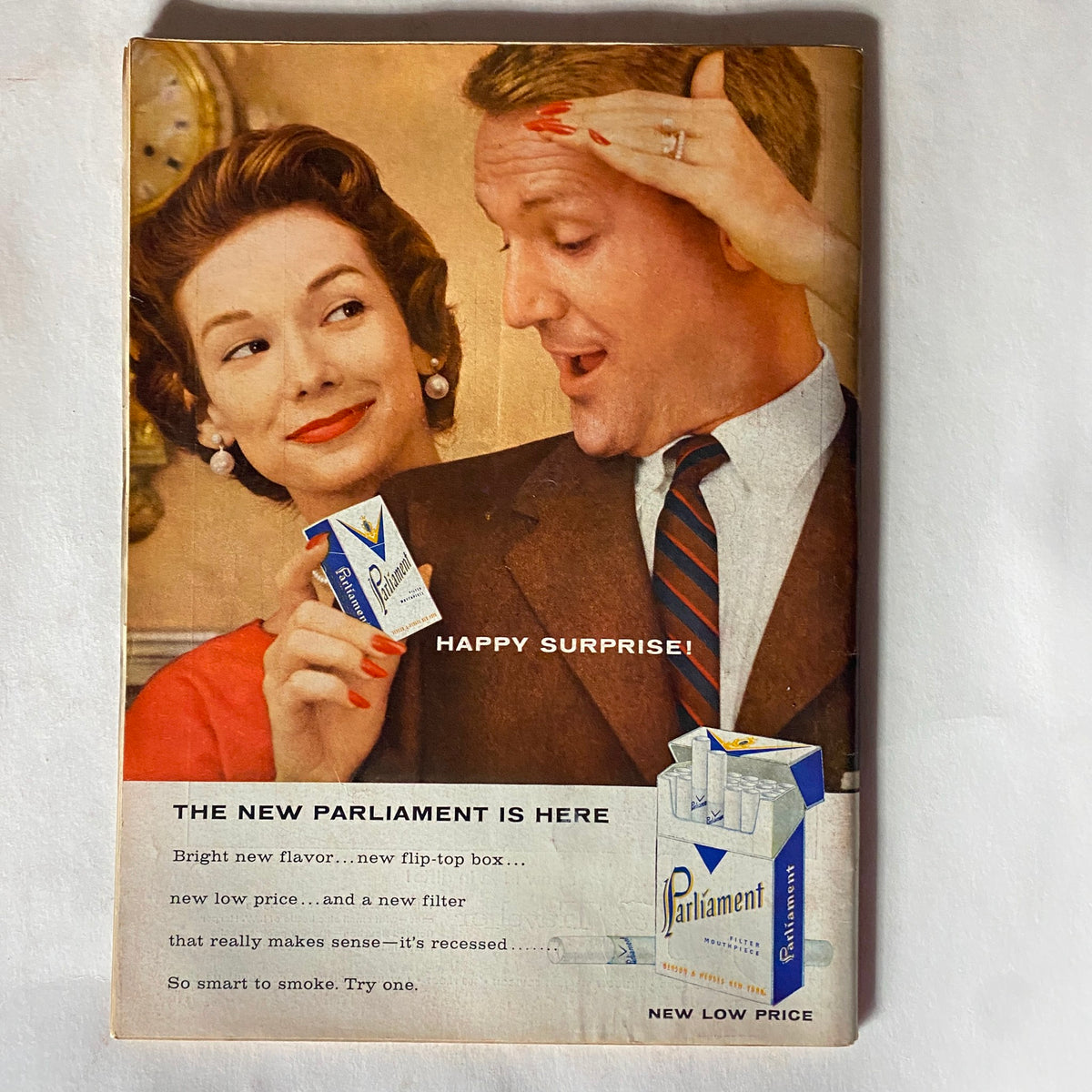 Vintage advertisement from Time Magazine November 19, 1956 featuring a man and woman promoting the new Parliament cigarettes, showcasing the product's features with the slogan 'Happy Surprise' and highlighting its unique packaging design.
