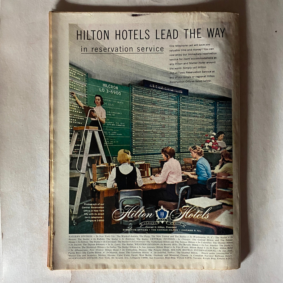 Vintage advertisement from VTG Time Magazine August 6, 1956 promoting Hilton Hotels and their reservation services, reflecting mid-20th century marketing.