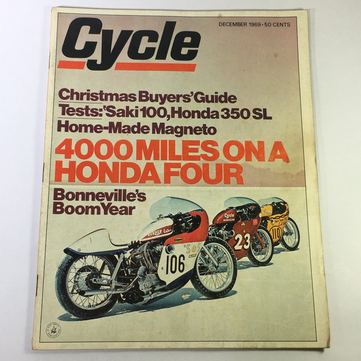 Cover of VTG Cycle Magazine December 1969 featuring the title '4000 Miles on a Honda Four' alongside racing motorcycles. The cover includes articles on Christmas Buyers' Guide, tests on Saki 100 and Honda 350 SL, and highlights Bonneville's Boom Year. A vintage collectible for motorcycle enthusiasts.