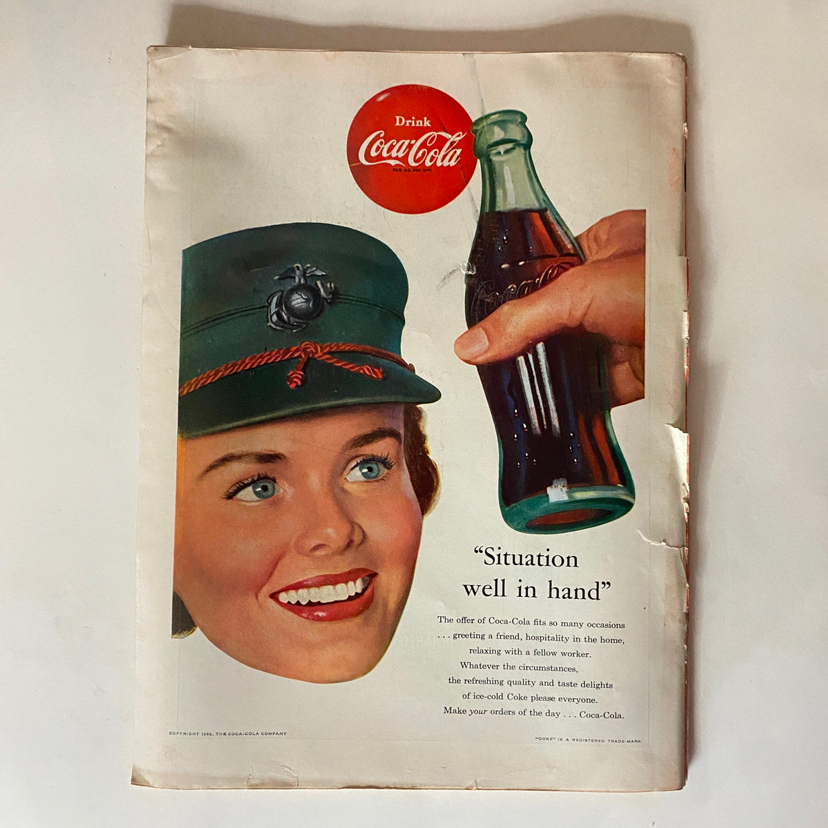 Advertisement page in Time Magazine from February 16, 1953 featuring a Coca-Cola ad with a smiling woman in a military-style hat.