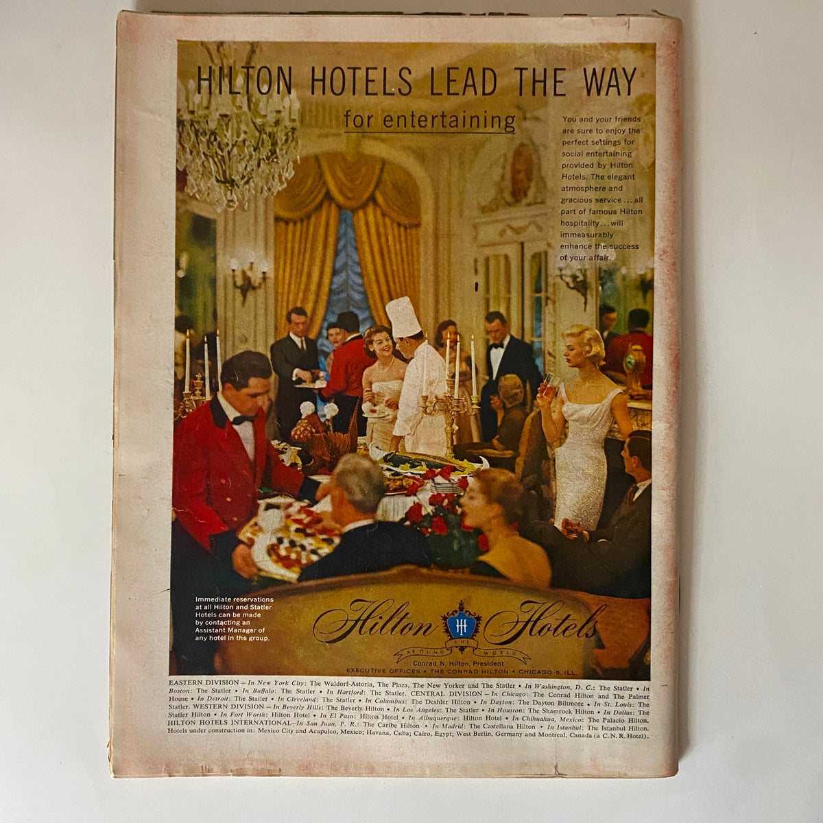 Advertisement for Hilton Hotels from the vintage Time Magazine May 14, 1956 Vol 67 No. 20 featuring Marilyn Monroe. The image showcases elegant dining and entertaining at Hilton Hotels.