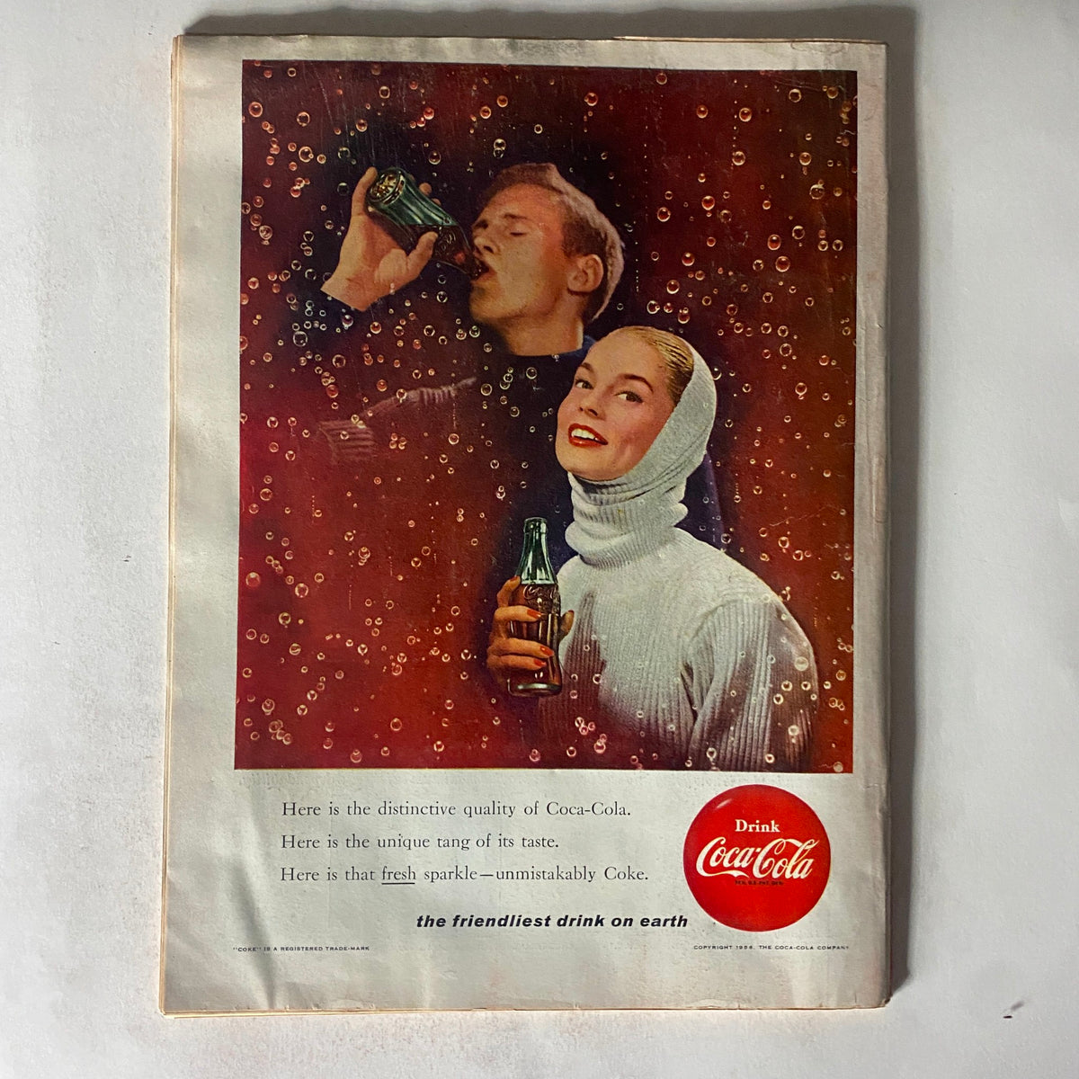 Vintage Coca-Cola advertisement featuring a couple enjoying drinks, highlighted with bubbles and the text 'Drink Coca-Cola' showcasing the distinctive quality and unique taste of Coca-Cola. Part of the VTG Time Magazine January 30, 1956 collection.