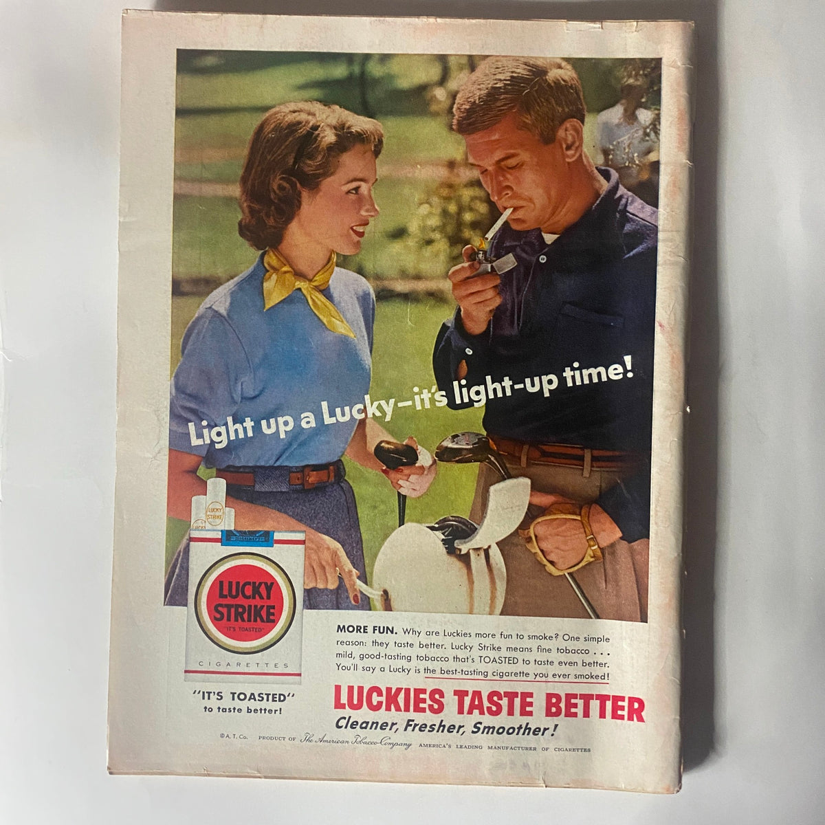 Back cover of VTG Time Magazine April 2, 1956, showcasing a vintage Lucky Strike cigarette advertisement with a couple enjoying a light-up moment.