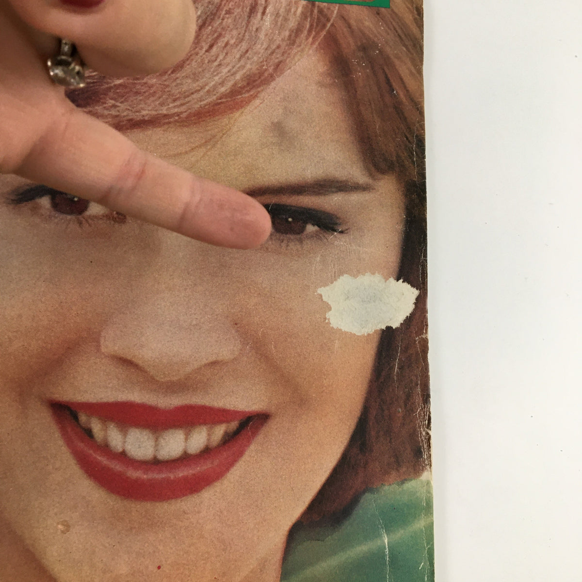 Close-up of the cover of Ladies' Home Journal Magazine May 1961, featuring a woman's smile with a minor blemish on her cheek.