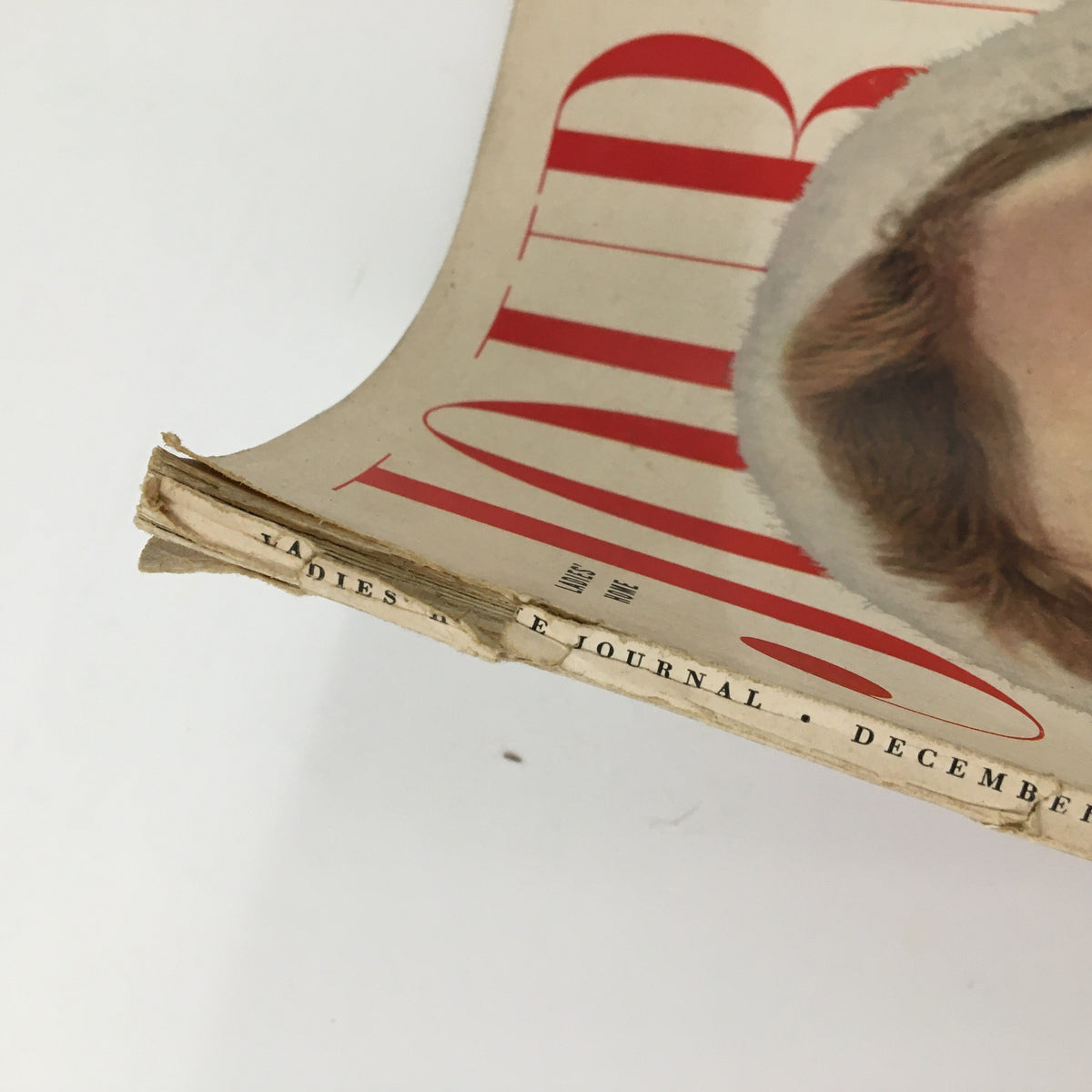 Side view of the Ladies' Home Journal Magazine December 1954 displaying the wear along the spine, showcasing its vintage character and history.