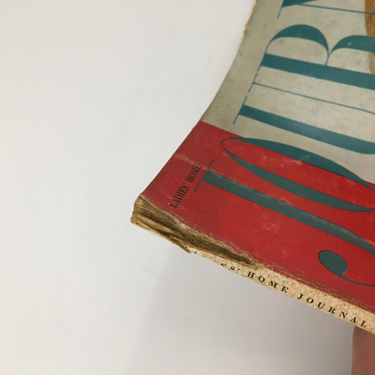 Close-up of the spine of the Ladies' Home Journal Magazine October 1960, showing the title and slight wear, indicative of its vintage appeal.