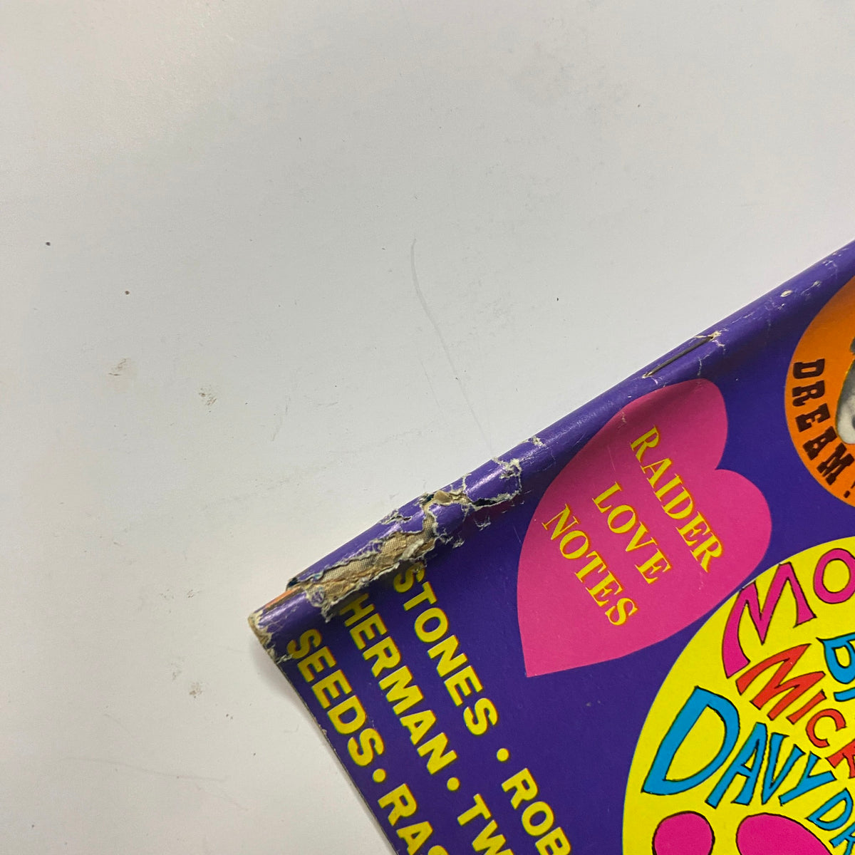 Close-up of damaged edge of Teen Date Book Magazine November 1967 showcasing wear, including a tear on the spine and colorful section headers related to teen idols and contests.