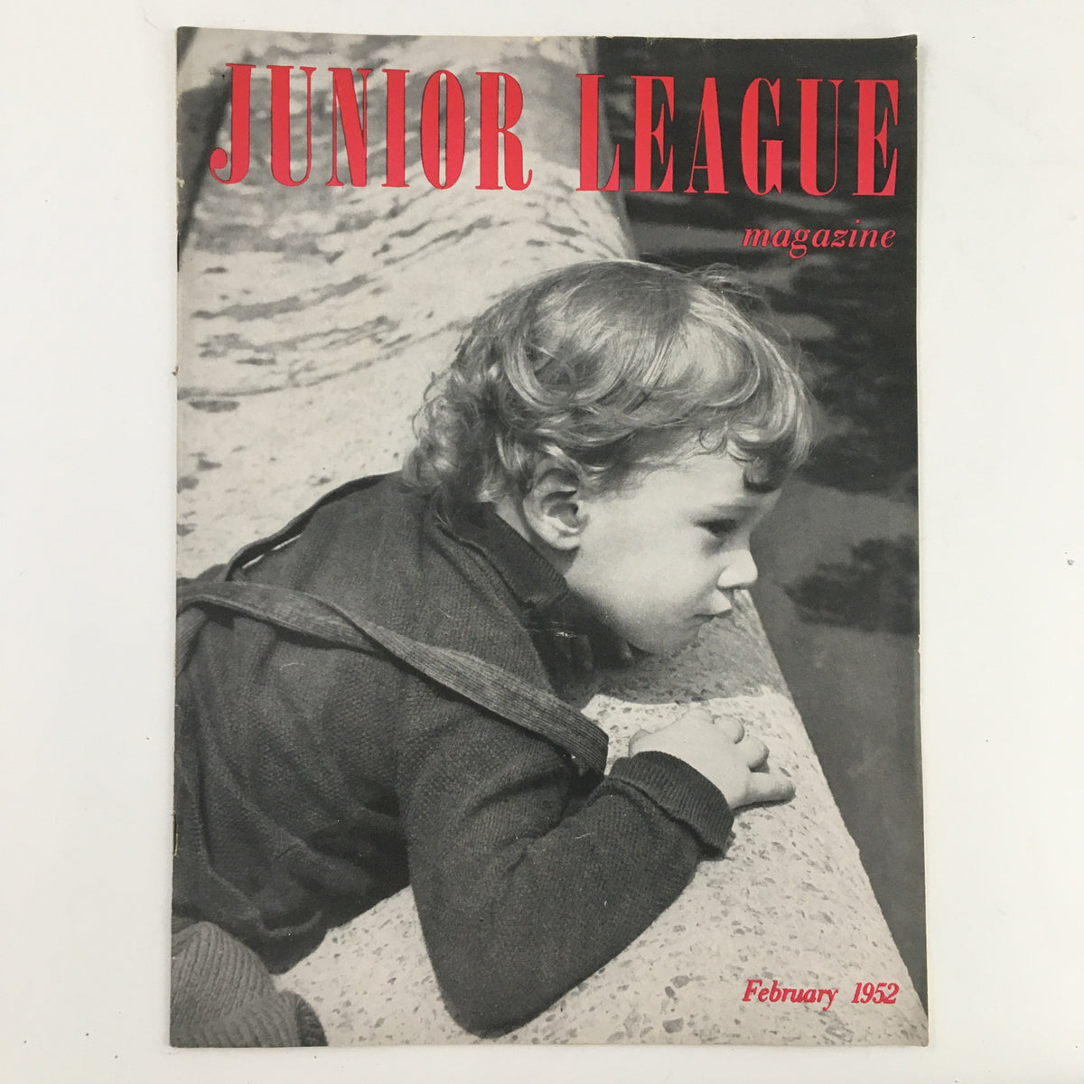 Cover of Junior League Magazine February 1952 featuring a young boy thoughtfully gazing over a ledge, with the title prominently displayed in red.
