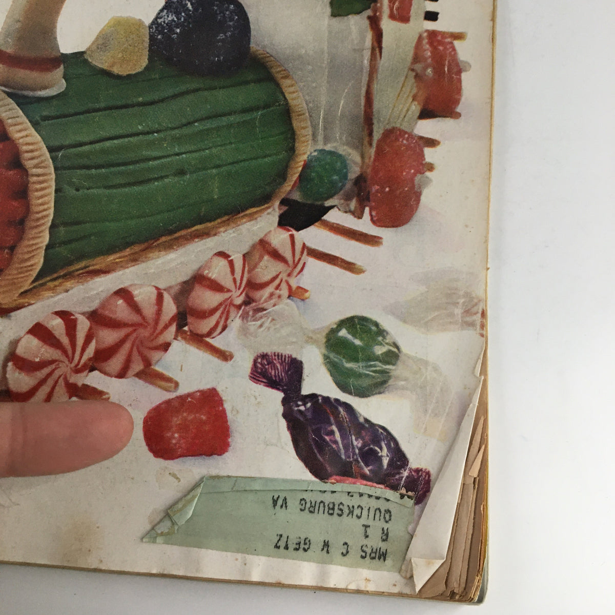 Close-up of the cover details of Women's Home Companion Magazine December 1954, showcasing a candy train decoration featuring festive sweets with an address label that adds vintage character.
