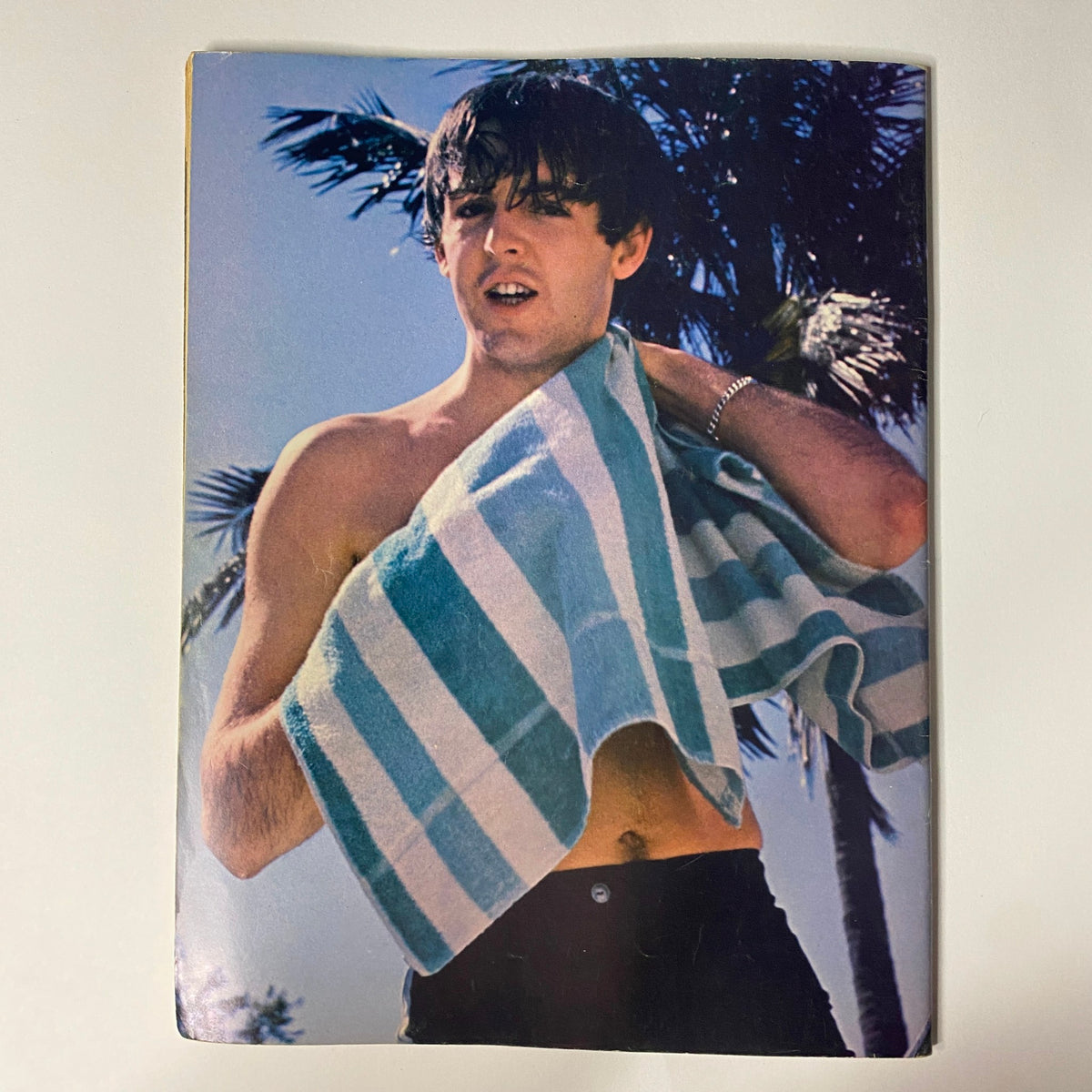 1966 16 Scoop: The Beatles Whole True Story image of a young Paul McCartney casually posing outdoors with a towel, reflecting the laid-back lifestyle of the Fab Four.