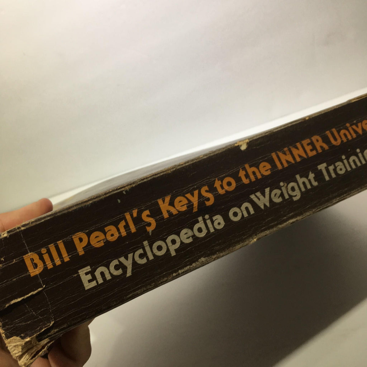 Side view of 'Keys to the Inner Universe Vol. 1 1980 Third Printing by Bill Pearl' highlighting the spine with 'Encyclopedia on Weight Training' and the title.