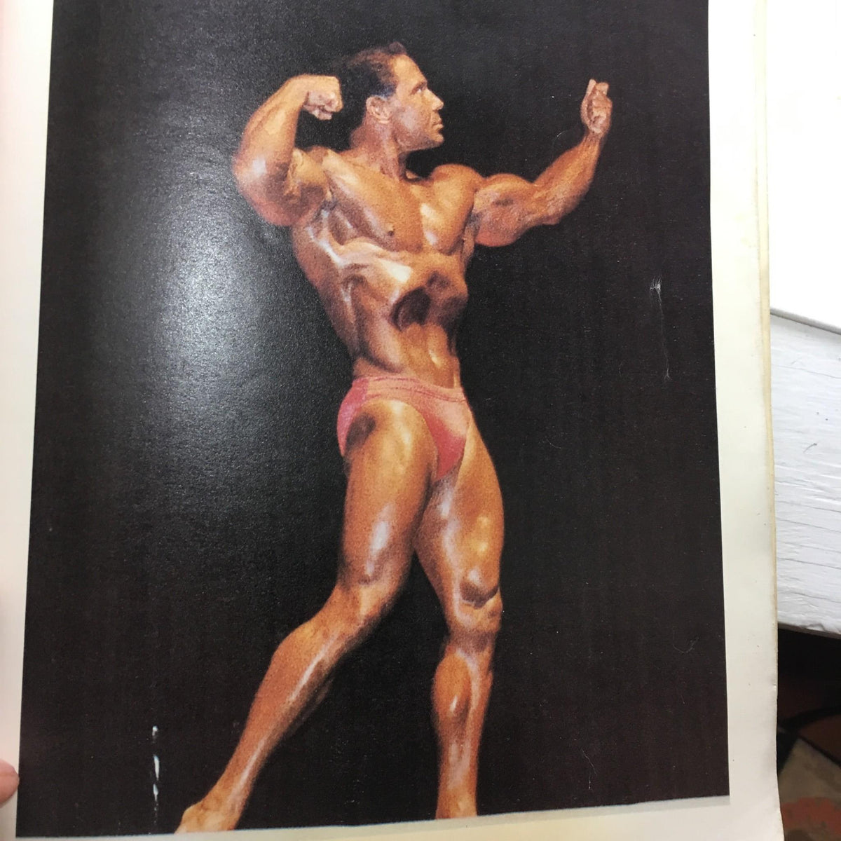 A muscular bodybuilder posing in 'Keys to the Inner Universe Vol. 1', illustrating the magazine's focus on fitness and wellness.