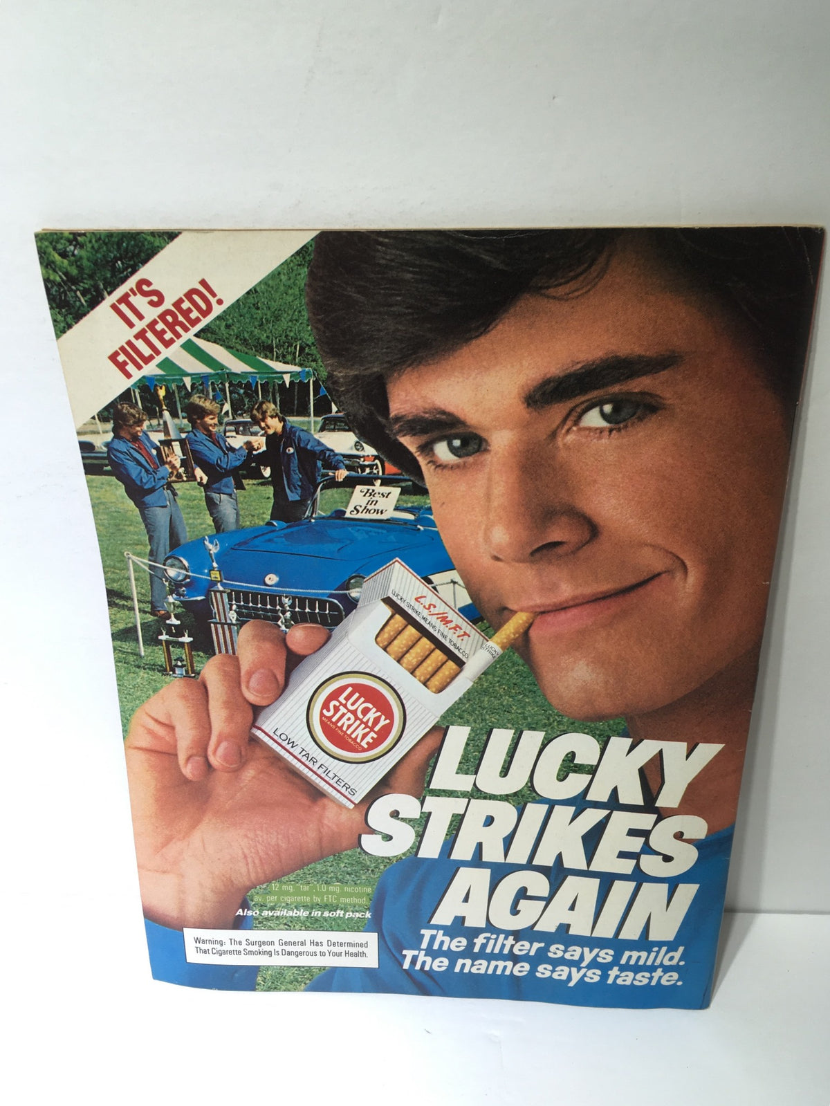 Vintage advertisement for Lucky Strike cigarettes on the cover of a magazine, featuring a young man promoting the product.