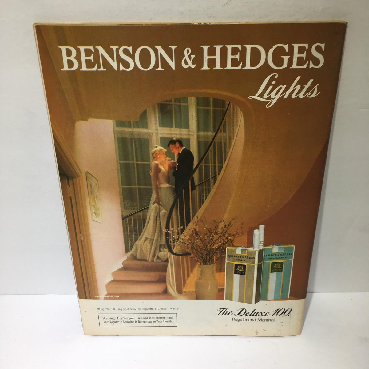 Cover of the Benson & Hedges Lights advertisement featuring a couple by a staircase, highlighting vintage cigarette branding.