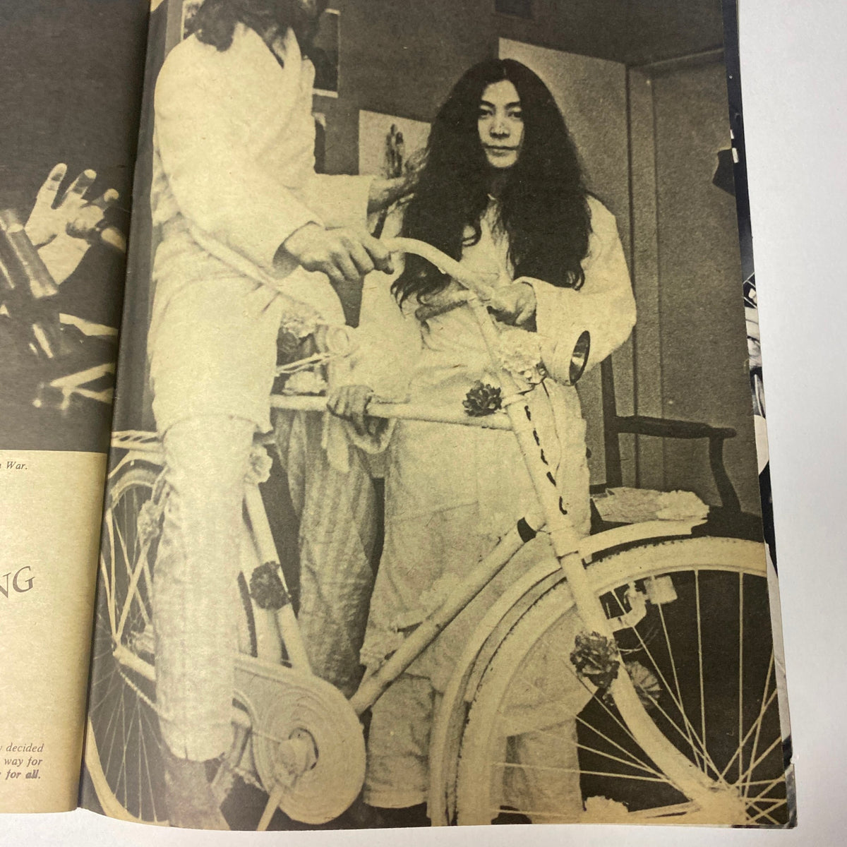 A nostalgic moment featuring John Lennon and Yoko Ono in their iconic photoshoot for the 'Beatles Special John Lennon and Yoko Ono: Their Love Book Collector's Edition.' Yoko Ono sits on a white bicycle, capturing their unique love and artistic collaboration. This image celebrates their relationship and connection during the 1960s.